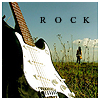 A pixelated image shows a white electric guitar with a brown neck against a blue sky, with the word "ROCK" in black letters above and a person standing in a grassy field in the background.