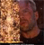 A pixelated image of two figures in close proximity, one with light-colored hair and the other with darker hair, against a dark background with warm tones.