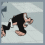 Pixelated cartoon character in black outfit with white accents performs four distinct poses against light blue background.