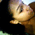 A person with dark hair and light skin is shown in a close-up, looking upward with eyes partially closed.