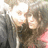 Pixelated static image of two figures in close proximity with one figure's face partially visible and a bright light source behind them.