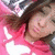 Pixelated image of a person with dark hair wearing pink clothing against a blurred background.