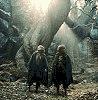 Two figures in dark cloaks stand in a rocky cave with light beams, their poses shifting slightly across frames.