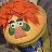 Pixelated cartoon character with orange hair and green eyes next to black text on a white background.