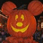 A pixelated orange pumpkin with Mickey Mouse ears, a smiling face, and 'trick or treat' text below it on black background.