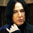 Pixelated image of a person with long dark hair and a dark robe, next to red background with text.