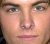 A pixelated close-up of a human face showing eyes, nose, and mouth with light skin tone against a neutral background.
