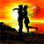 Silhouetted couple embracing on a hilltop at sunset with a large heart symbol, transitioning from a side view to a front view.