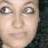 Two side-by-side static images of a person with long dark hair, one showing the face without sunglasses and the other wearing large black sunglasses.