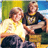 Two figures in casual clothing sit side-by-side against a green and blue background with yellow accents.