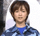 A person with short brown hair wears a blue camouflage jacket over a blue shirt, shown in two sequential poses with a white circular background.