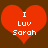 Two red heart shapes with white text "I Luv Sarah" on a brown background, one heart slightly blurred.