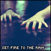 A hand with red-painted nails touches a reflective surface, with text "SET FIRE TO THE RAIN" below.