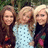 Three people stand side-by-side in a pixelated image with a blurred green background; the central figure wears a light blue dress with dark blue dots.