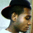 Pixelated close-up of a person wearing a dark wide-brimmed hat, light skin tone, and brown hair visible beneath the brim.