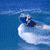 Animated sequence of a surfer riding a wave, showing progression from upright stance to falling into the water.