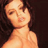 Static pixelated image of a person's upper body with dark hair and light skin tone against a dark background, rendered in low resolution with visible dithering and color blending.