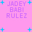 Pixelated text 'JADEY BABI RULEZ' in purple on pink background with cyan plus signs, static display.