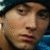 Two side-by-side pixelated frames of a person wearing a dark beanie and light-colored hoodie, with subtle facial expression differences between the left and right frames.