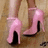 A static image shows a person's feet in pink high-heeled shoes on a wooden floor, with pixelated text surrounding the image.
