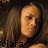 A 48x48 pixel animated contact sheet showing two side-by-side frames of a person with long brown hair and light skin, each displaying different text below the face against a dark background.