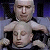 Pixelated static image shows two human faces layered vertically against a dark blue and gray background.