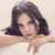 Static pixelated image of a person with long dark hair resting their head on crossed arms against a light background.