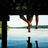 A pixelated image shows a girl and guy hanging from a structure over water, with text about friendship and falling for each other.