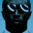 Pixelated face with glowing blue eyes against a light blue background, dark skin tone, no visible clothing or accessories.