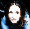 A woman with long brown hair and blue clothing appears in three showing facial expression changes from neutral to smiling