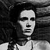 Black-and-white pixelated image of a person with long dark hair wearing a light-colored top against a dark background.