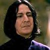 Static image of a person with long dark hair wearing a dark high-collared garment and a purple shoulder accent, set against a blurred background.