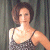A pixelated image of a woman with short brown hair wearing a gray tank top, standing against a dark curtain background next to green text reading 'Original Icons .com'.
