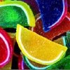 A static image of overlapping, brightly colored, textured fruit slices with distinct outlines and highlights.