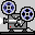 Pixelated film projector icon with two reels, gray body, blue-and-black spools, red indicator light, and white accents on a light gray background.