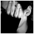 A 50x50 pixel animated buddy icon showing a grayscale close-up of hands holding a small object against black background, paired with green text logo on dark green background.