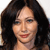 A pixelated close-up of a person with long dark hair, light skin, and red lips, wearing a dark top against a light background.