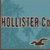 Pixelated image with blue background showing partial text 'HOLLISTER Co' and a brown bird-like shape in the lower right.