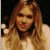 A pixelated contact sheet showing two frames of an animated buddy icon featuring a woman with long blonde hair on the left and green text reading "Original Icons .com" on the right against a dark background.