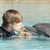 A pixelated image shows a person with brown hair and light skin lying in water, with a dolphin visible to the right.