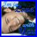 Static pixelated image of a person with light skin lying down, wearing dark clothing and blue headband-like object against blurred background.