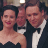 Static 48x48 pixel icon showing two people in formal attire against a dark background with subtle lighting effects.