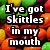 Pixelated image of colorful candy with overlaid text reading "I've got Skittles in my mouth wanna taste the rainbow?".
