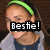 Pixelated image of a person with light brown hair wearing a green headband, gray long-sleeve shirt, and dark blue top, with a black banner displaying 'Bestie!' over the eyes.