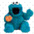 Blue muppet-like character with open mouth and raised arm holding a cookie, next to full and partial cookies on white background.