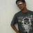 A person wearing a dark gray t-shirt with a white skull graphic stands against a light background, shifting position across frames.