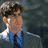 Pixelated static image of a person with brown hair and blue clothing against a dark background, rendered in low-resolution 256x256 pixels.