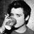 Black-and-white image of a person in three sequential poses: drinking from glass, turning head right, and looking down.