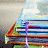Stack of books with a purple bookmark, an open book showing text, and 'READ!' in pixelated black letters on white background.