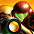 Pixelated static icon of a green-skinned character with brown hair wearing a dark outfit, holding a glowing yellow circular object against an orange-yellow background.